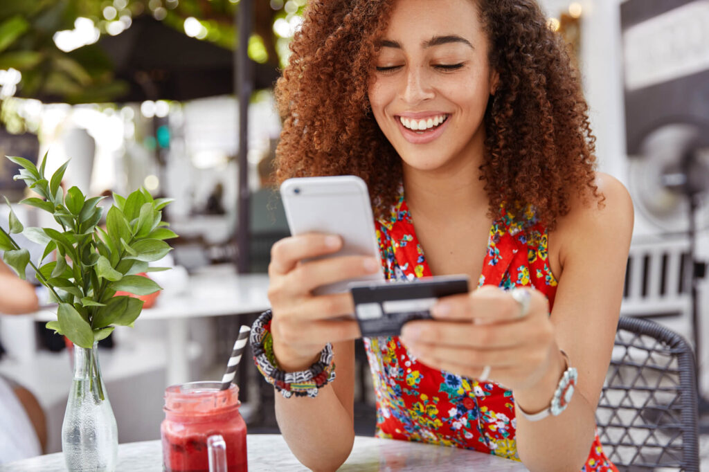 woman holding credit card and cell phone