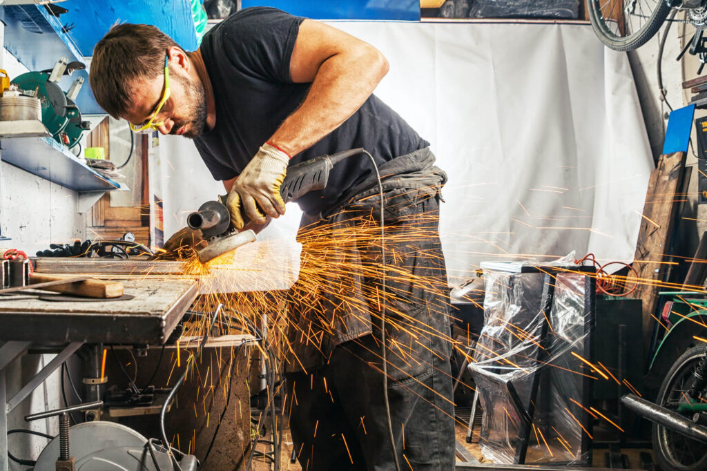 man using angle grinder and creating sparks