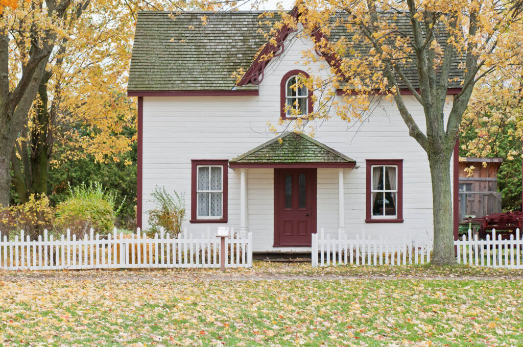 white house and picket fence in autumn