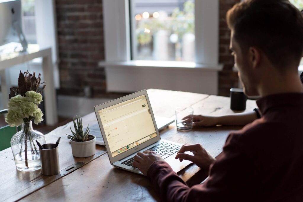 man at table using laptop