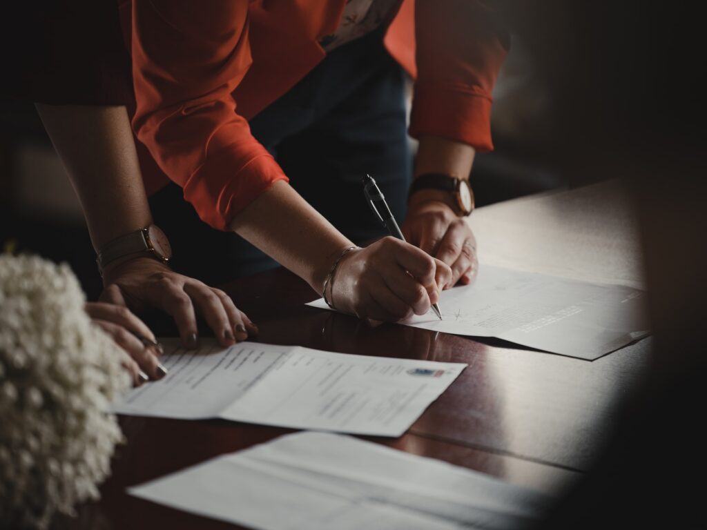 people signing papers on a desk