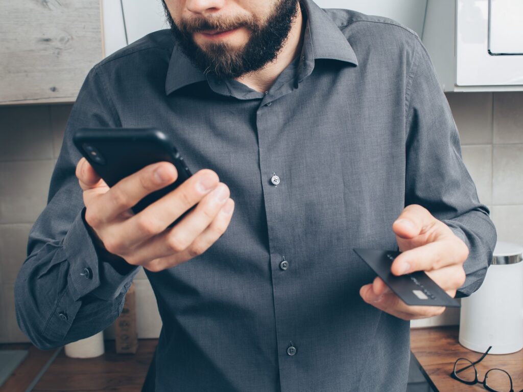 man looks at card scam and phone